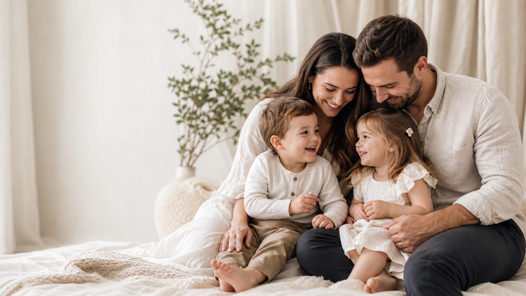Parents and two young children sharing a warm, candid moment in a bright studio